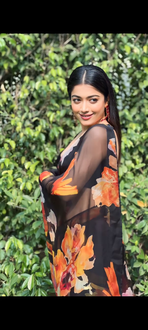 Model styling black printed georgette saree with ethnic jewelry
